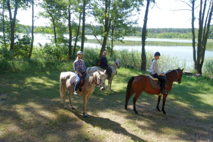 three riders at a lake